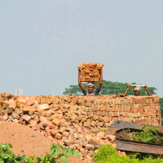 A man is carrying a lot of bricks on his head in the south of Bangladesh