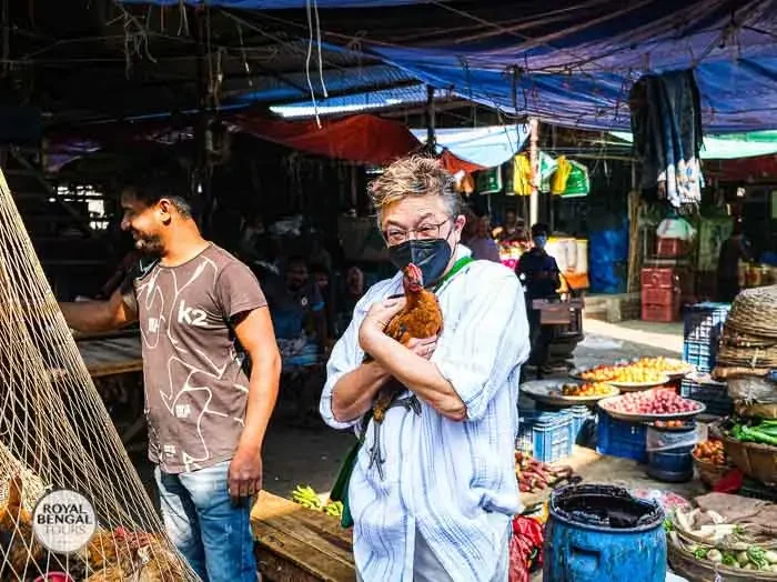 Tourist interacting with a vendor at Kawran Bazar, a marketplace in Dhaka, Bangladesh
